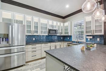 A kitchen with a granite countertop and stainless steel appliances.